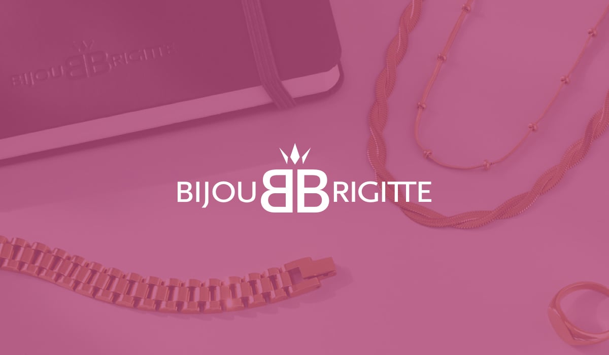 A notebook and golden necklaces on a white table, with the logo of the workforce management solution user Bijou Brigitte in the foreground. 