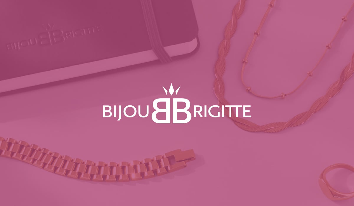 A notebook and golden necklaces on a white table, with the logo of the workforce management solution user Bijou Brigitte in the foreground.