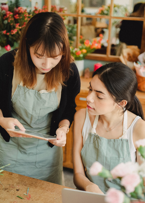 Zwei Mitarbeiterinnen schauen sich gemeinsam die KPIs für Ihr Einzelhandelsgeschäft an.